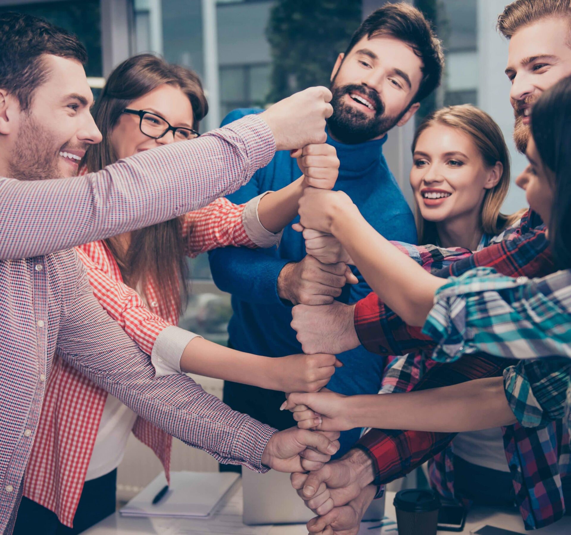 Happy businesspeople putting their fist on top of each other and laughing