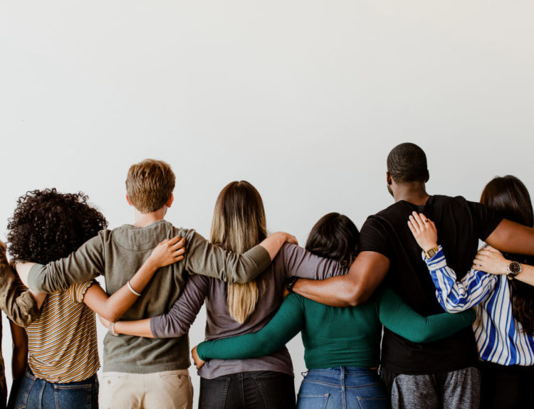 Vue arrière de personnes diverses se serrant les unes contre les autres